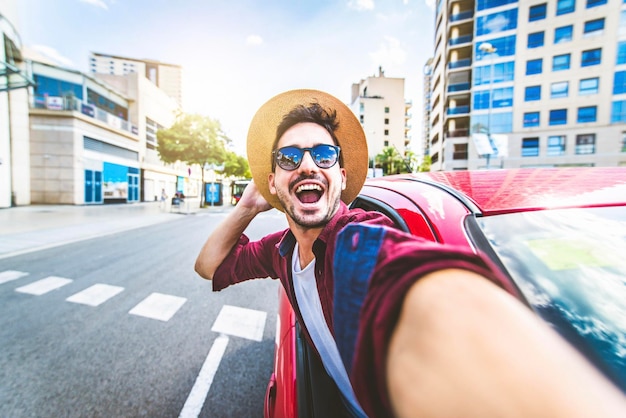 Junger gutaussehender Mann, der Selfie-Foto im Auto macht