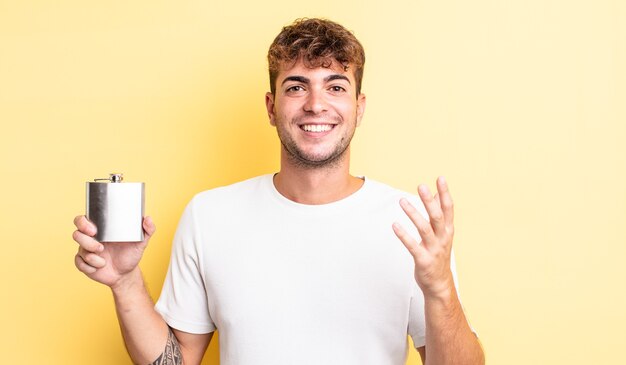 Junger gutaussehender Mann, der sich glücklich fühlt, überrascht, eine Lösung oder Idee zu realisieren. Konzept der Alkoholflasche