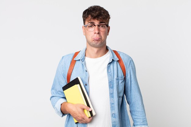 Junger gutaussehender Mann, der sich traurig und weinerlich fühlt, mit einem unglücklichen Blick und Weinen. universitätsstudentenkonzept