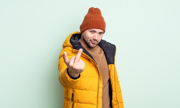 Junger gutaussehender Mann, der sich wütend, verärgert, rebellisch und aggressiv fühlt. Konzept für kaltes Wetter