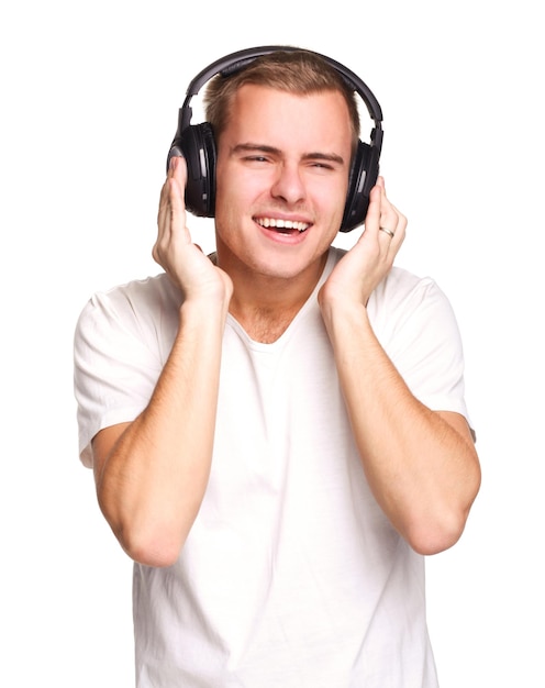 Junger gutaussehender Mann im weißen T-Shirt, der Musik über Kopfhörer hört