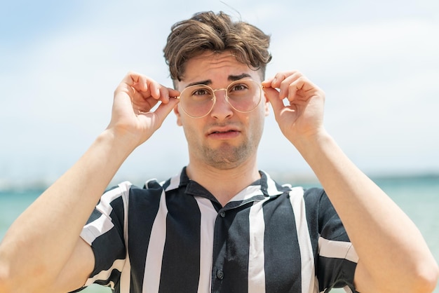 Junger gutaussehender Mann mit Brille und frustriertem Gesichtsausdruck