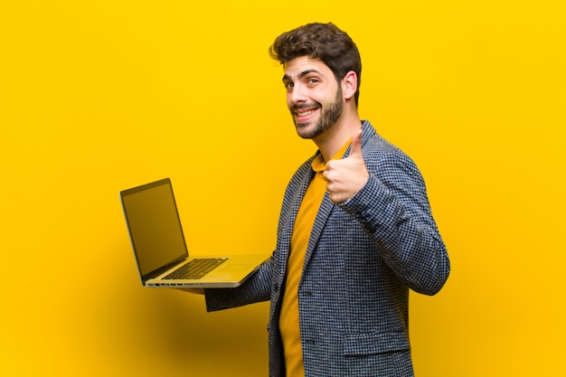 Junger gutaussehender Mann mit einer Laptoporange