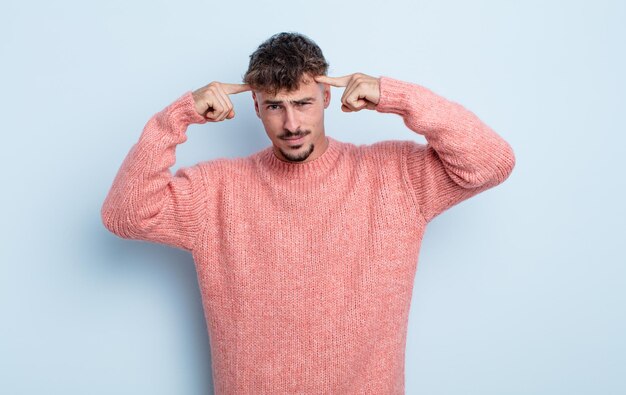 Foto junger gutaussehender mann mit ernstem und konzentriertem blick, brainstorming und nachdenken über ein herausforderndes problem