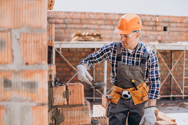 Junger Handwerker, der ein Haus baut