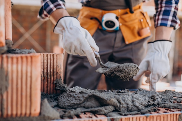 Junger Handwerker, der ein Haus baut