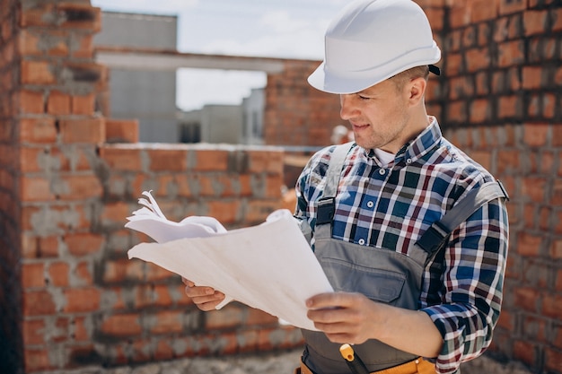 Junger Handwerker, der ein Haus baut