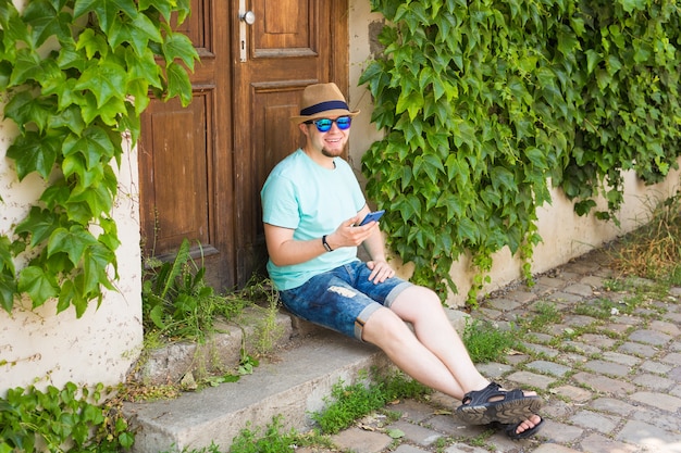 Junger Hipster-Mann mit Smartphone im Freien
