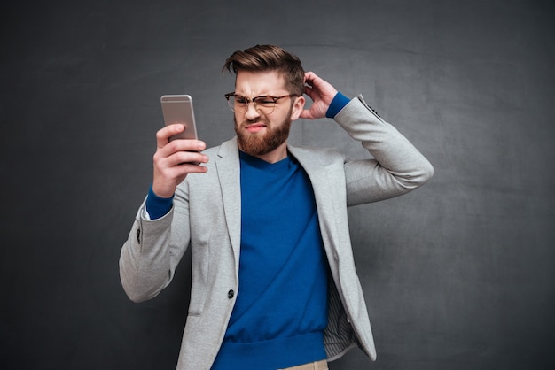 Junger Hipster mit Telefon im Studio