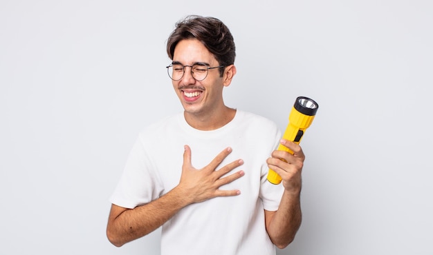Junger hispanischer Mann, der laut über einen urkomischen Witz lacht. Laternenkonzept