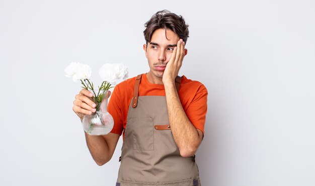 junger hispanischer mann, der sich nach einem ermüdenden gelangweilt, frustriert und schläfrig fühlt. floristisches Konzept