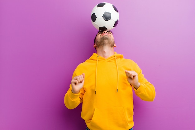 Junger hispanischer Mann mit einem Fußballpurpur