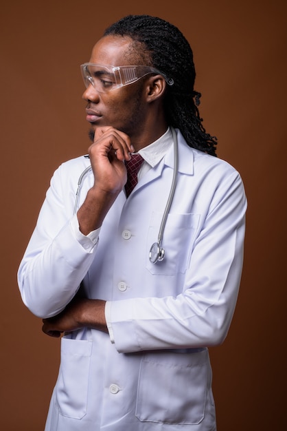 Junger hübscher afrikanischer Mannarzt, der Schutzbrille trägt