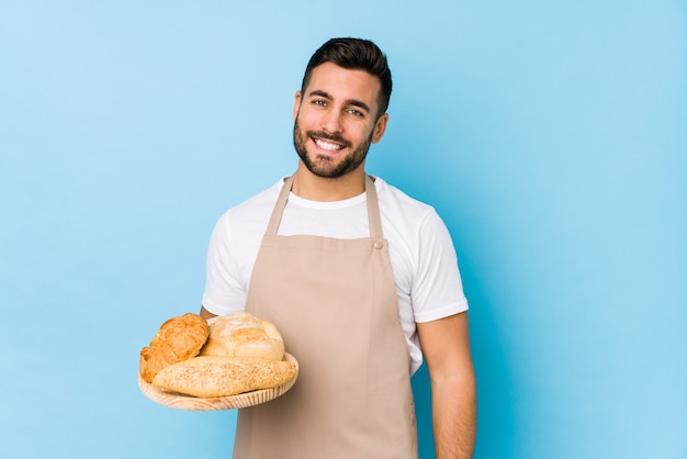 Junger hübscher Bäckermann lokalisiert glücklich, lächelnd und fröhlich.