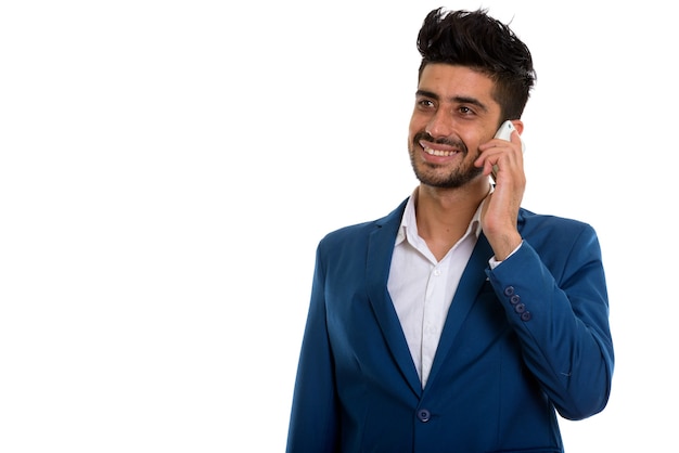 Junger hübscher bärtiger persischer Geschäftsmann, der am Telefon spricht