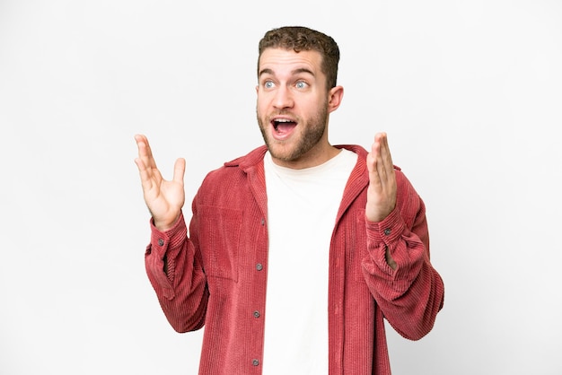 Junger, hübscher, blonder Mann auf einem isolierten weißen Hintergrund mit überraschendem Gesichtsausdruck