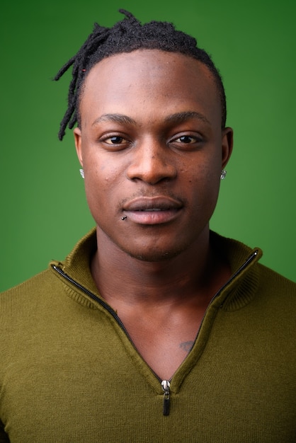 Junger hübscher Mann aus Kenia gegen Grün