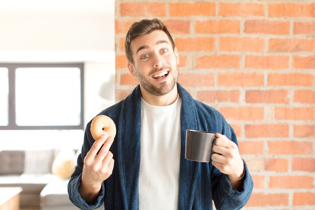 Junger hübscher Mann, der einen Kaffee zu Hause trinkt