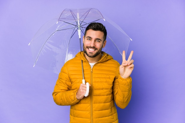 Foto junger hübscher mann, der einen regenschirm hält