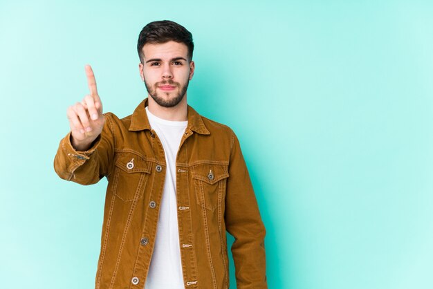 Junger hübscher Mann, der Nummer eins mit Finger zeigt.