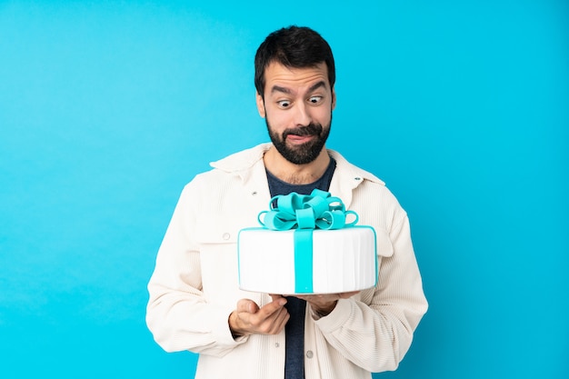 Junger hübscher Mann mit einem großen Kuchen