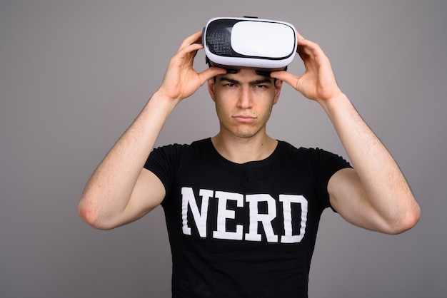 Junger hübscher Nerdmann, der virtuelles Realitätskopfset trägt