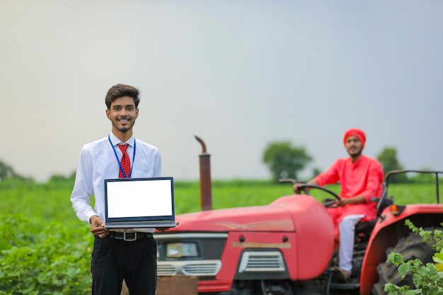 Junger indischer Agronom, der Laptop-Bildschirm zeigt