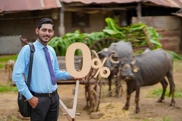 Junger indischer Agronom oder Finanzier mit Null-Prozent-Zeichen oder -Symbol auf Rinderfarm