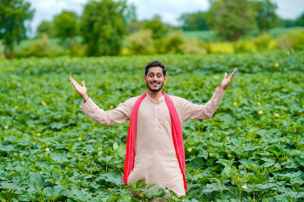 Junger indischer Bauer am grünen Landwirtschaftsfeld.