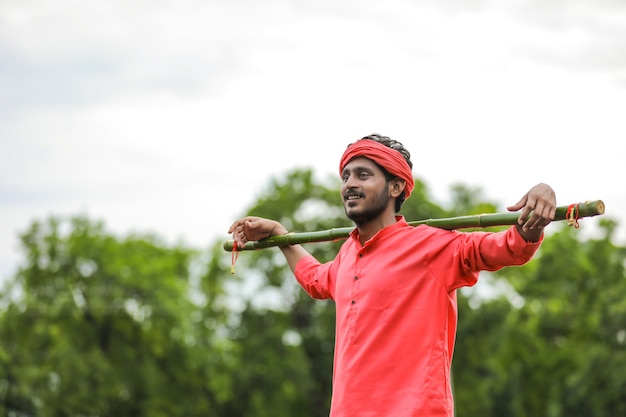 Junger indischer Bauer in einer traditionellen Tracht auf dem Feld
