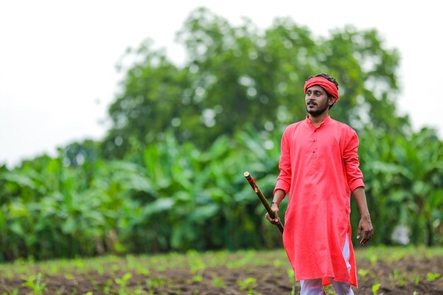 Junger indischer Bauer in einer traditionellen Tracht auf dem Feld