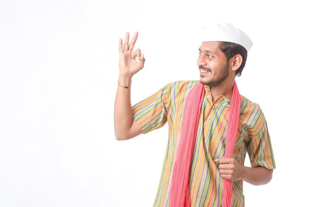 Junger indischer Bauer in traditioneller Kleidung und Ausdruck auf weißem Hintergrund.