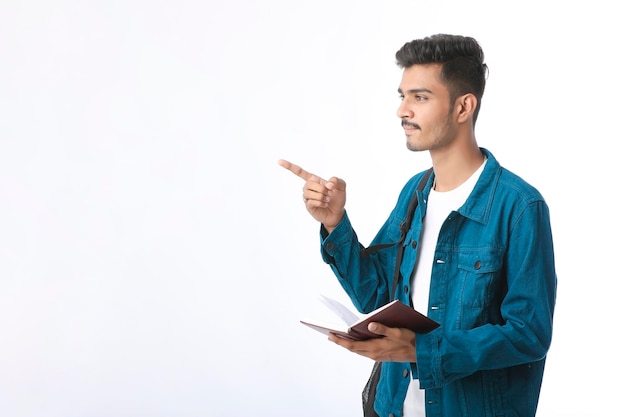 Junger indischer mann, der tagebuch in der hand hält und eine idee denkt.