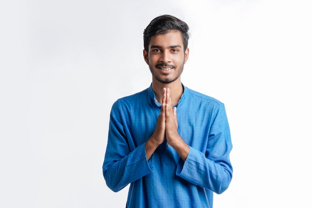 Junger indischer Mann in traditioneller Kleidung und Namaste oder Willkommensgeste