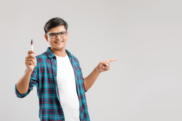 junger indischer Mann mit Brille und etwas auf ein Glas zu schreiben Schreibtafel