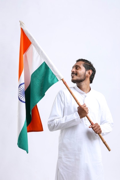 Junger indischer Mann mit indischer Nationalflagge in der Hand auf weißem Hintergrund holding