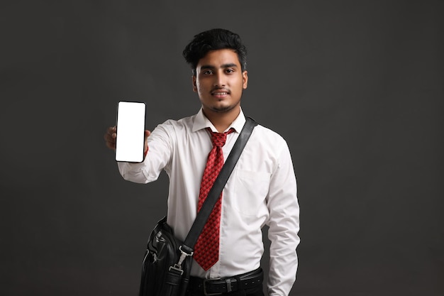 Foto junger indischer offizier oder student mit smartphone-bildschirm