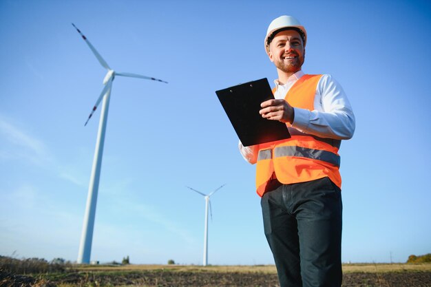 Junger Ingenieur Mann sucht und überprüft Windkraftanlagen auf dem Feld