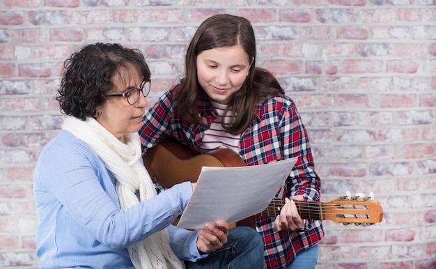 Junger Jugendlicher, der lernt, die Gitarre mit seinem Lehrer zu spielen