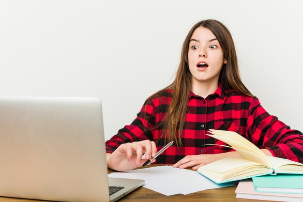 Junger Jugendlicher, der zurück zu ihrem Programm tut die Hausarbeit zurückgeht, die entsetzt ist.