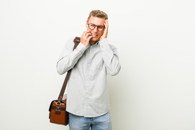 Junger kaukasischer Geschäftsmann, der trostlos jammert und weint.