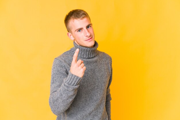 Junger kaukasischer gutaussehender Mann, der mit dem Finger auf Sie zeigt, als ob die Einladung näher kommt.