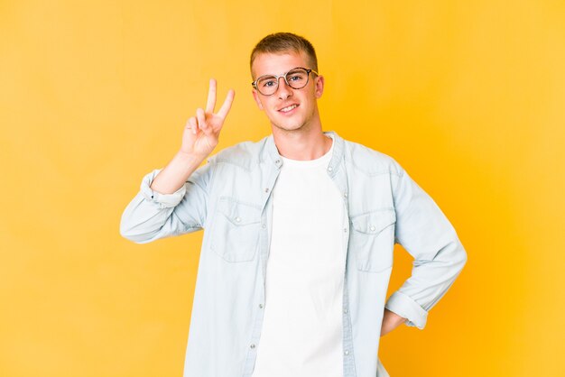 Junger kaukasischer gutaussehender Mann, der Nummer zwei mit den Fingern zeigt.