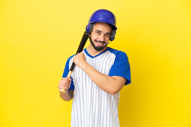 Junger kaukasischer Mann, der Baseball spielt, isoliert auf gelbem Hintergrund, der einen Sieg feiert?