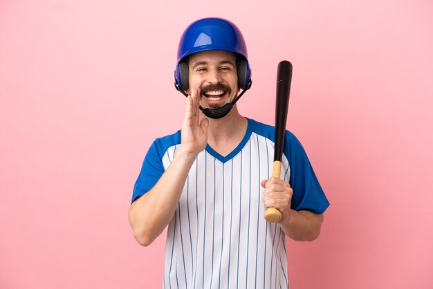 Junger kaukasischer Mann, der Baseball spielt, isoliert auf rosa Hintergrund, der mit weit geöffnetem Mund schreit