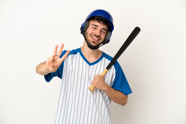 Junger kaukasischer Mann, der Baseball spielt, isoliert auf weißem Hintergrund, glücklich und zählt drei mit den Fingern