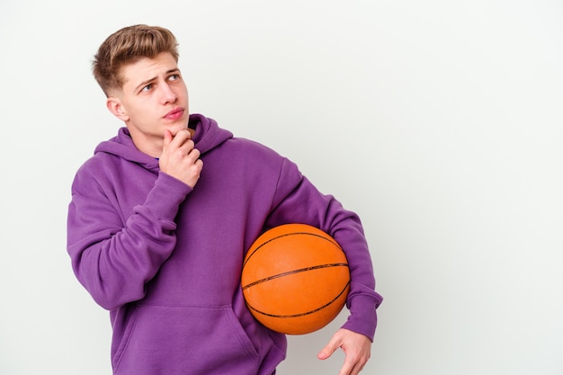 Junger kaukasischer Mann, der Basketball lokalisiert spielt