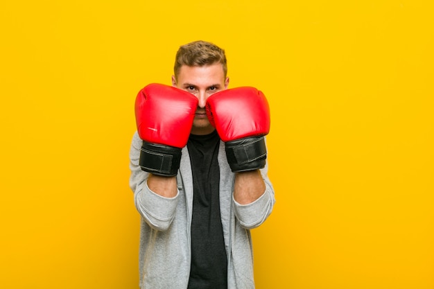 Junger kaukasischer Mann, der Boxhandschuhe trägt