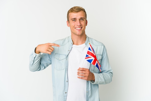 Junger kaukasischer Mann, der eine Flagge des Vereinigten Königreichs hält, lokalisiert auf weißen Wand beißenden Fingernägeln, nervös und sehr ängstlich.