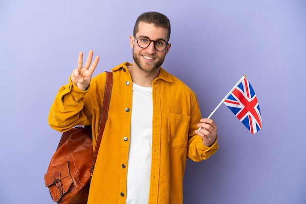 Junger kaukasischer Mann, der eine Großbritannienflagge lokalisiert hält